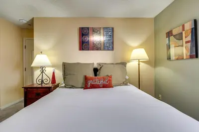 a bedroom with a white bed and two lamps at Half-Mi to Light Rail Greenwood Village Studio in Englewood