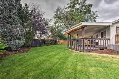 a house with a large deck on a lawn at Arvada Home with Deck and Game Room Near Olde Town! in Arvada