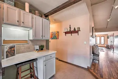 a kitchen with white cabinets and a long counter at Arvada Home with Deck and Game Room Near Olde Town! in Arvada