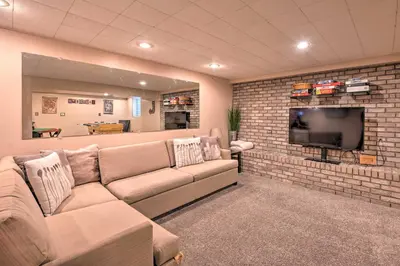 a living room with a couch and a tv at Arvada Home with Deck and Game Room Near Olde Town! in Arvada
