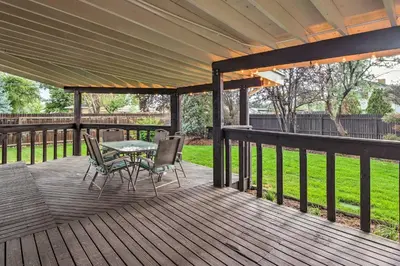 a patio with a table and chairs on a deck at Arvada Home with Deck and Game Room Near Olde Town! in Arvada