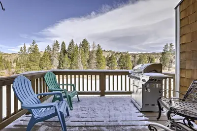 a patio with chairs and a grill on a deck at Winter Park Condo Hot Tub and Shuttle-Walk to Town in Winter Park