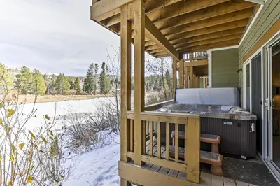 a wooden deck with a hot tub on a house at Winter Park Condo Hot Tub and Shuttle-Walk to Town in Winter Park