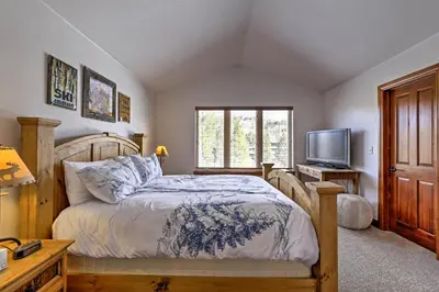 a bedroom with a bed and a tv and a window at Winter Park Condo Hot Tub and Shuttle-Walk to Town in Winter Park
