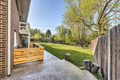 a backyard with a wooden fence and a yard at 11 Mi to Denver Zoo Lakewood Studio with Fire Pit! in Lakewood