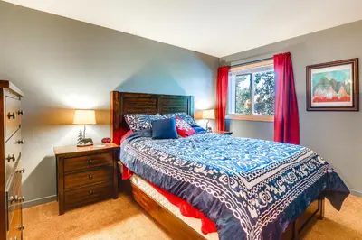 a bedroom with a bed and a dresser and a window at Stunning Mountain Views Silverthorne Condo! in Silverthorne