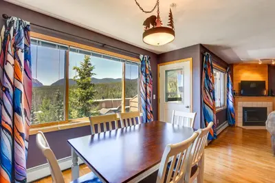 a dining room with a table and a large window at Stunning Mountain Views Silverthorne Condo! in Silverthorne