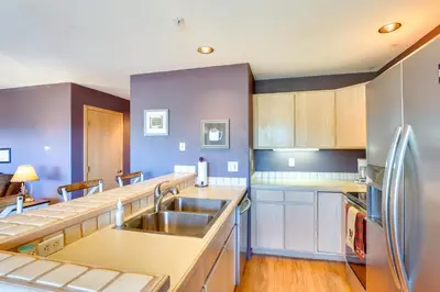 a kitchen with a sink and a refrigerator at Stunning Mountain Views Silverthorne Condo! in Silverthorne