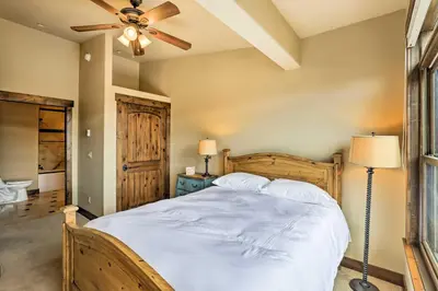 a bedroom with a large bed with a ceiling fan at Elegant Frisco Condo with Private Hot Tub and Views! in Frisco
