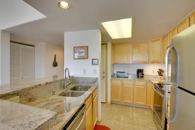 a kitchen with a sink and a refrigerator at 360 Mtn Views and Shared Hot Tub Cozy Frisco Condo! in Frisco