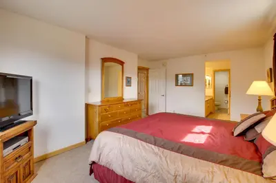 a bedroom with a large bed and a flat screen tv at 360 Mtn Views and Shared Hot Tub Cozy Frisco Condo! in Frisco