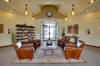 a waiting room with leather chairs and a table and a clock at 360 Mtn Views and Shared Hot Tub Cozy Frisco Condo! in Frisco