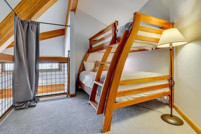 a bedroom with two bunk beds and a lamp at 10 Mi to Keystone Resort Cabin with Private Hot Tub in Silverthorne