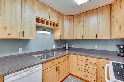 a kitchen with wooden cabinets and a sink at 10 Mi to Keystone Resort Cabin with Private Hot Tub in Silverthorne
