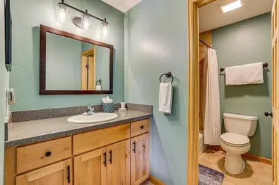 a bathroom with a sink and a toilet and a mirror at 10 Mi to Keystone Resort Cabin with Private Hot Tub in Silverthorne
