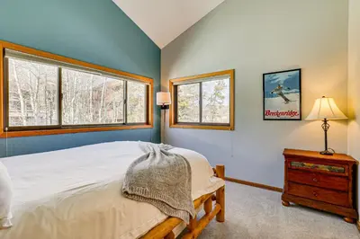 a bedroom with a bed and two windows at 10 Mi to Keystone Resort Cabin with Private Hot Tub in Silverthorne