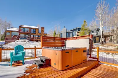 a deck with a hot tub and a blue chair at 10 Mi to Keystone Resort Cabin with Private Hot Tub in Silverthorne