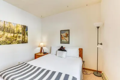 a white bedroom with a bed and a lamp at Mtn-View Gem with Community Perks in Silverthorne! in Silverthorne