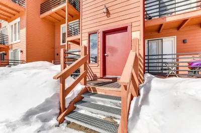 a house with a red door in the snow at Mtn-View Gem with Community Perks in Silverthorne! in Silverthorne