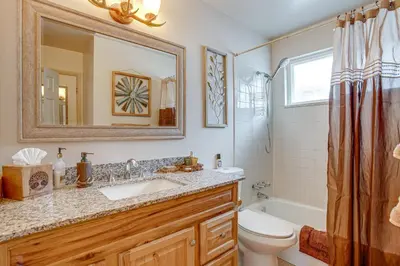 a bathroom with a sink and a toilet and a mirror at Near Red Rocks, Hiking and Skiing Kittredge Condo! in Kittredge