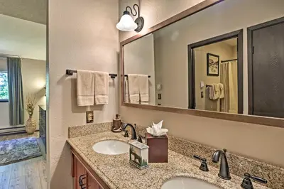 a bathroom with a sink and a large mirror at Condo with Pool and Hot Tub - Walk to DT Winter Park! in Winter Park