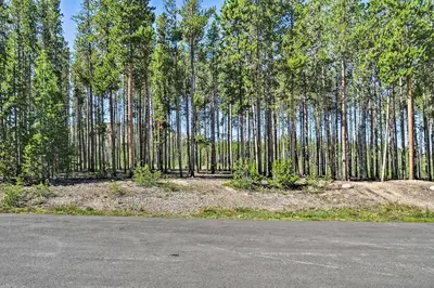 an empty road in front of a forest of trees at Condo with Pool and Hot Tub - Walk to DT Winter Park! in Winter Park