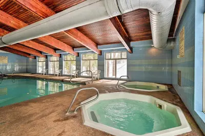a large swimming pool with a tub in a room at Condo with Pool and Hot Tub - Walk to DT Winter Park! in Winter Park