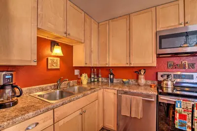 a kitchen with wooden cabinets and a sink at Balcony, Fire Pit and Grill Grand Lake Retreat! in Grand Lake
