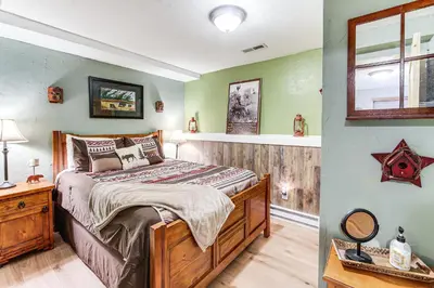a bedroom with a wooden bed and green walls at Balcony, Fire Pit and Grill Grand Lake Retreat! in Grand Lake