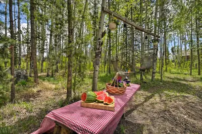 a picnic table with a basket of watermelons and a basket of watermelon at Balcony, Fire Pit and Grill Grand Lake Retreat! in Grand Lake
