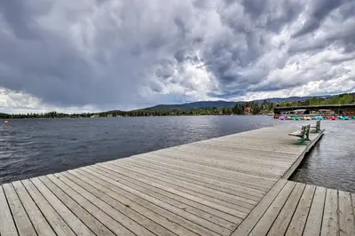 a wooden dock with two benches on the water at Balcony, Fire Pit and Grill Grand Lake Retreat! in Grand Lake