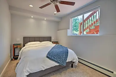 a bedroom with a bed with a ceiling fan and a window at 12 Mi to Red Rocks Morrison Home with Deck in Morrison