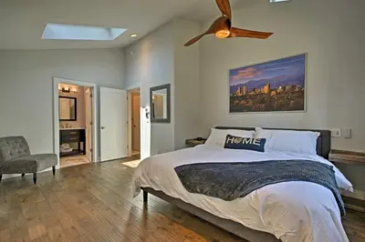 a bedroom with a large bed and a ceiling fan at 12 Mi to Red Rocks Morrison Home with Deck in Morrison