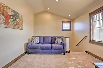 a blue couch in a living room with a window at Mtn-View Fraser Home with Hot Tub - Near Skiing! in Fraser