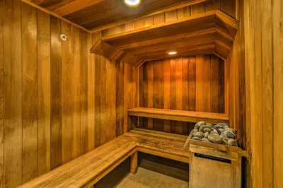 a wooden sauna with a bench and rocks in it at 4 Mi to Breckenridge Resort Condo with Sauna Access in Breckenridge