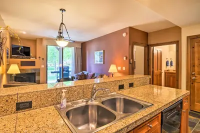 a kitchen with a sink and a living room at 4 Mi to Breckenridge Resort Condo with Sauna Access in Breckenridge