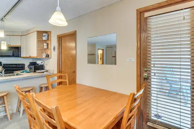 a kitchen and dining room with a wooden table and chairs at Ski-InandSki-Out Winter Park Condo with Hot Tub Access in Winter Park
