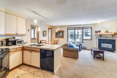 a kitchen and living room with a couch and a table at Ski-InandSki-Out Winter Park Condo with Hot Tub Access in Winter Park