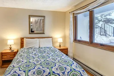 a bedroom with a bed and a window at Ski-InandSki-Out Winter Park Condo with Hot Tub Access in Winter Park