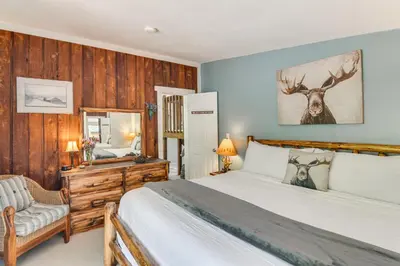 a bedroom with a bed with a deer picture on the wall at Cabin on Clear Creek A Hobbits Retreat! in Black Hawk