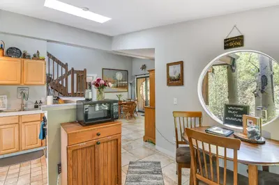 a kitchen and dining room with a tv and a table at Cabin on Clear Creek A Hobbits Retreat! in Black Hawk
