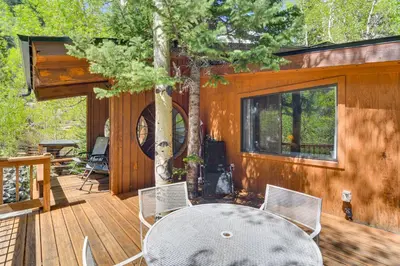 a patio with a table and chairs on a wooden deck at Cabin on Clear Creek A Hobbits Retreat! in Black Hawk