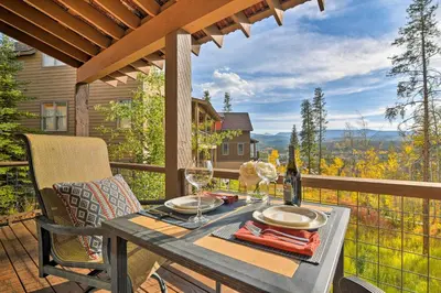 a table with wine glasses on a deck with a view at Winter Park Area Cabin, Hot Tub and Mountain Views! in Fraser