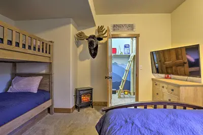 a bedroom with a bunk bed and a fire place at Winter Park Area Cabin, Hot Tub and Mountain Views! in Fraser