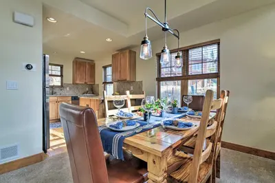 a kitchen and dining room with a wooden table at Winter Park Area Cabin, Hot Tub and Mountain Views! in Fraser