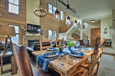 a dining room and living room with a wooden table at Winter Park Area Cabin, Hot Tub and Mountain Views! in Fraser