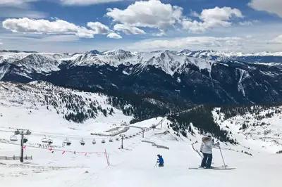two people skiing on a ski slope with a ski lift at Winter Park Area Cabin, Hot Tub and Mountain Views! in Fraser