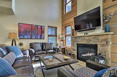 a living room with leather furniture and a fireplace at Winter Park Area Cabin, Hot Tub and Mountain Views! in Fraser