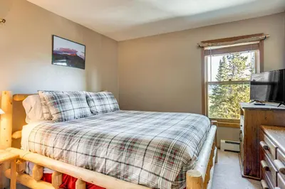 a bedroom with a bed and a tv and a window at Relax in our hot tub after world class skiing in Silverthorne