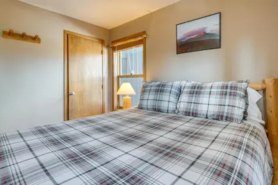 a bedroom with a bed with a plaid blanket at Relax in our hot tub after world class skiing in Silverthorne